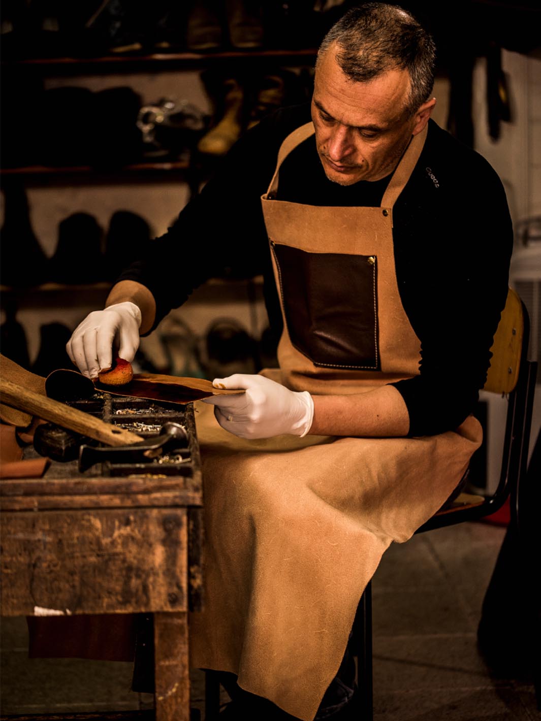 artigiano che pittura il cuoio nella sua bottega artigianale