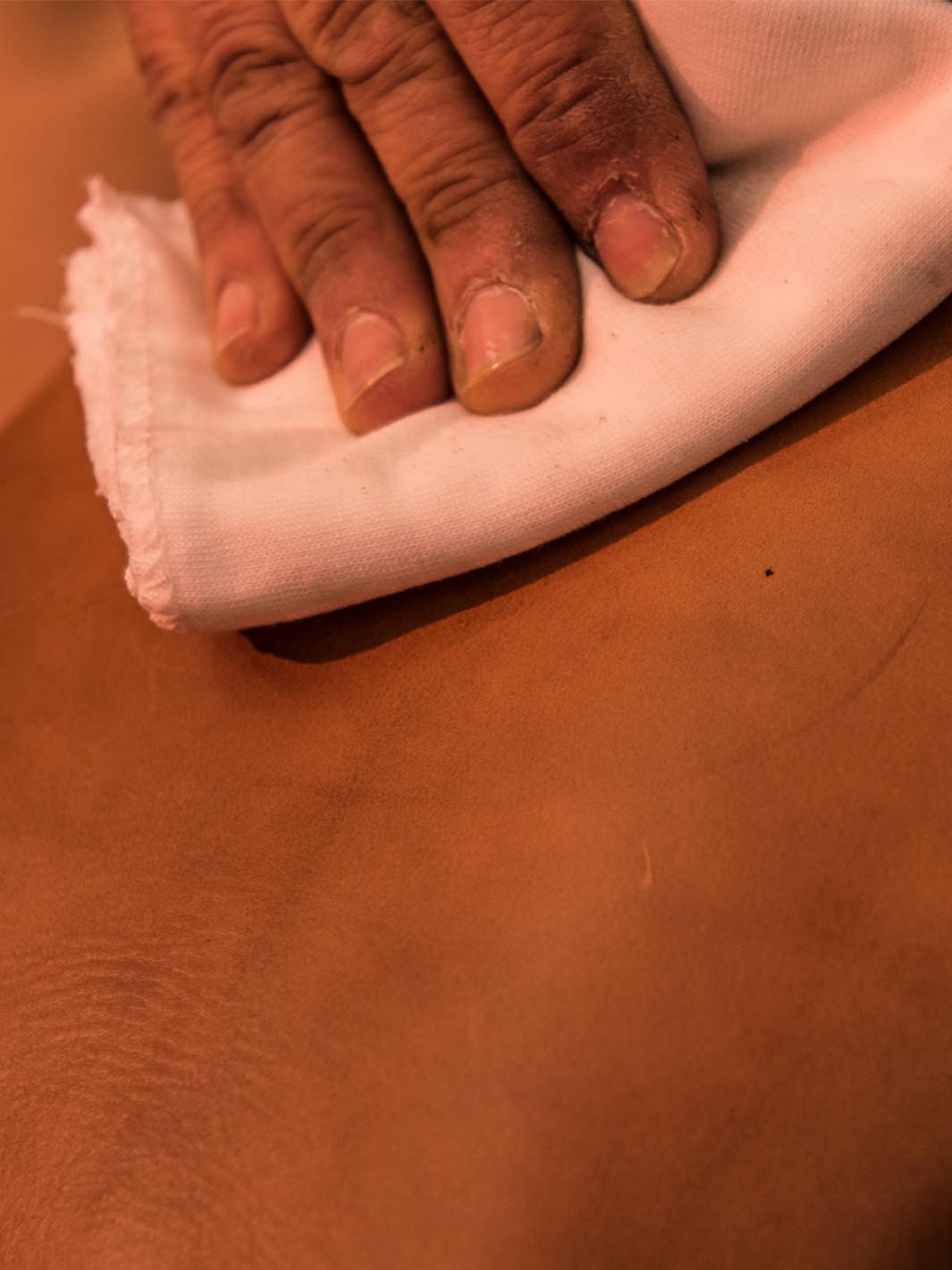 Artigiano che lucida il cuoio con un panno di cotone